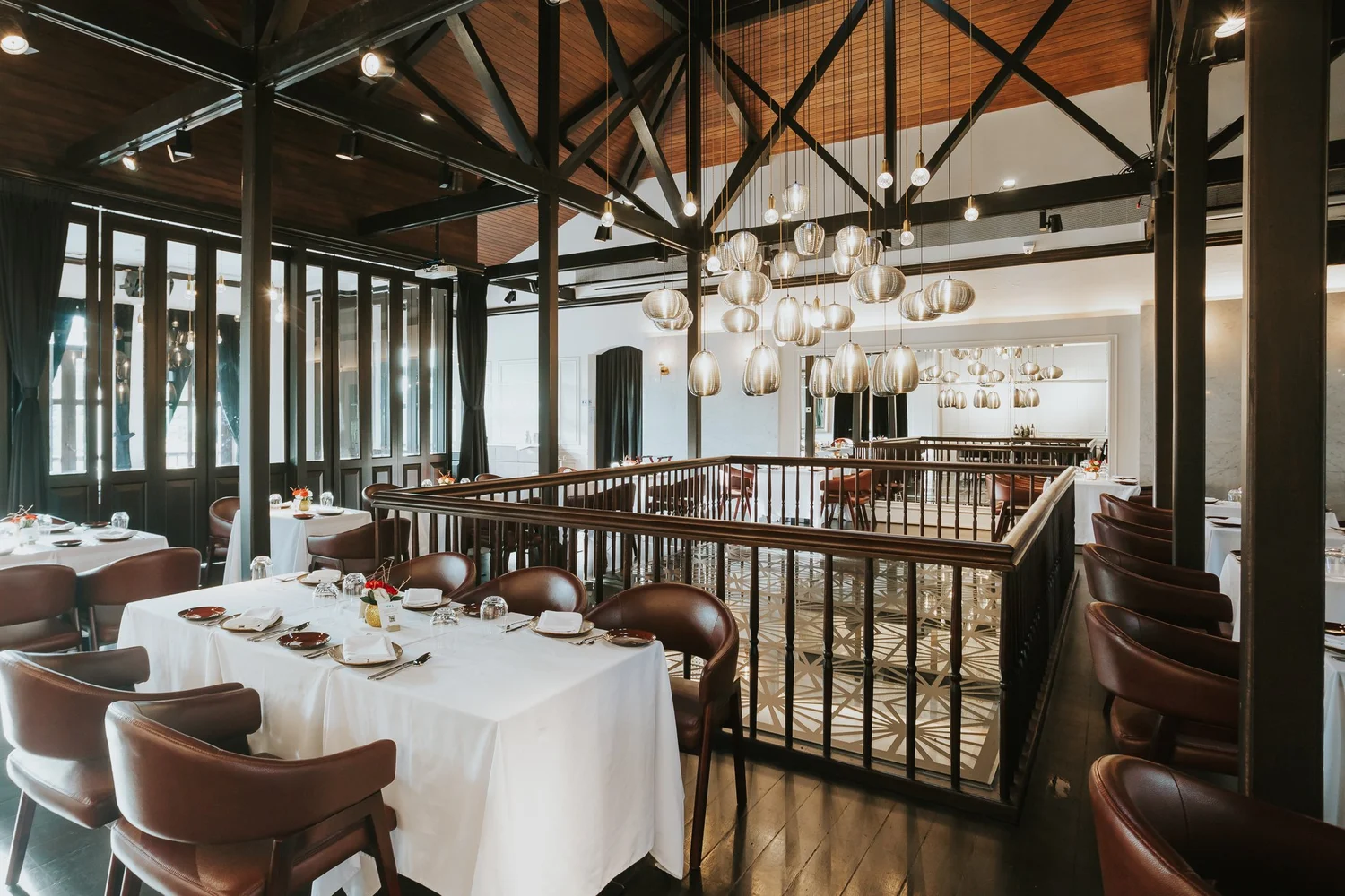UNA restaurant interior at The Alkaff Mansion with elegant chandeliers and white-clothed tables